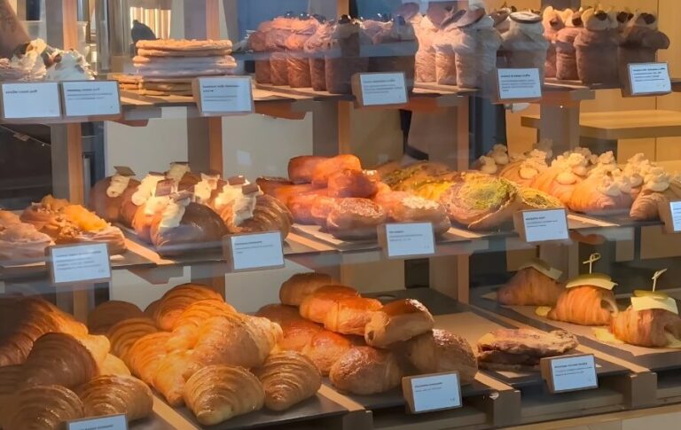 A tempting array of pastries and breads, beautifully displayed in a bakery window