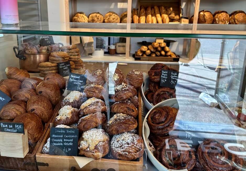 A tempting array of pastries, from flaky croissants to sweet rolls, displayed in a bakery window