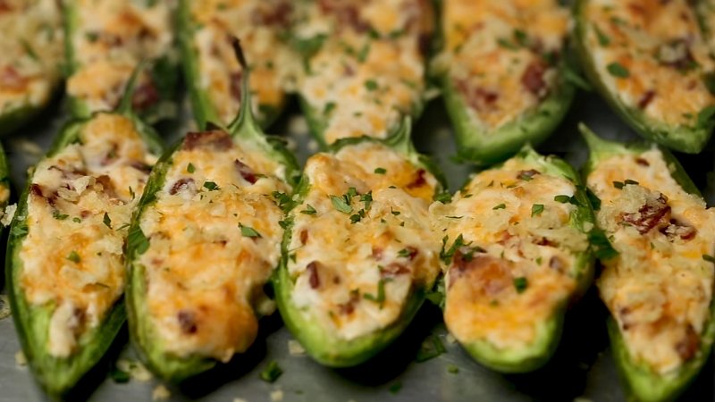 Halved jalapeños filled with a creamy bacon and cheese mixture, baked until golden and topped with chopped herbs