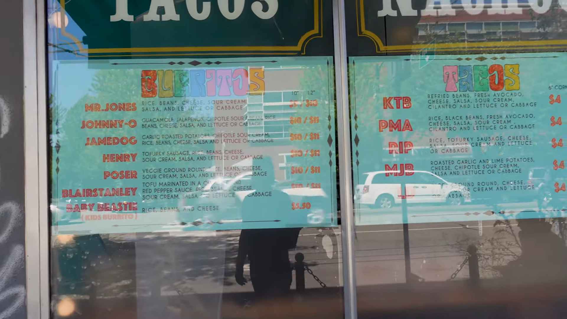 Menu board of Budgie’s Burritos showing vegetarian and vegan burrito and taco options with fun names