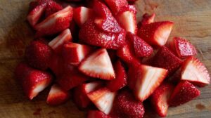 Close-up of freshly cut strawberries on a wooden board