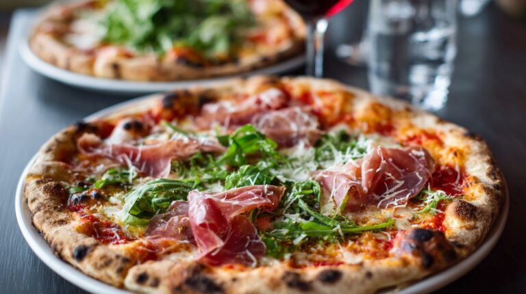 Close-up of a wood-fired pizza topped with prosciutto, arugula, and parmesan on a table in Vancouver restaurant