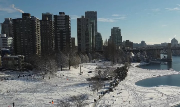 A snowy urban park with people enjoying outdoor activities
