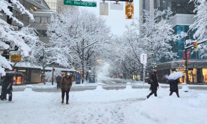 Snow-covered city street with bundled pedestrians